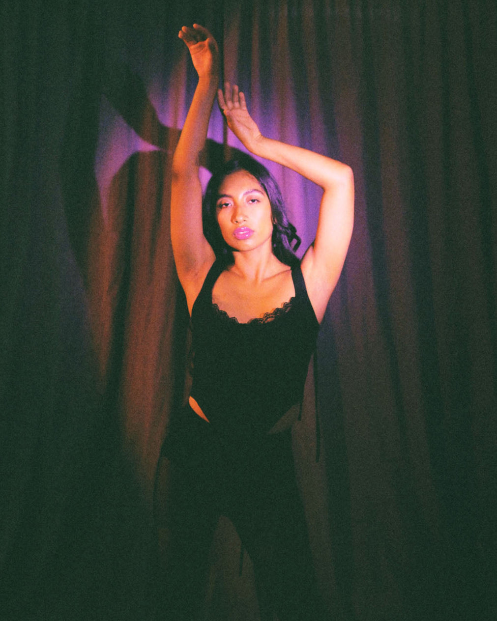 Model wearing black corset top with lace trim and ribbon ties, handcrafted in cotton by Mariana by Alba