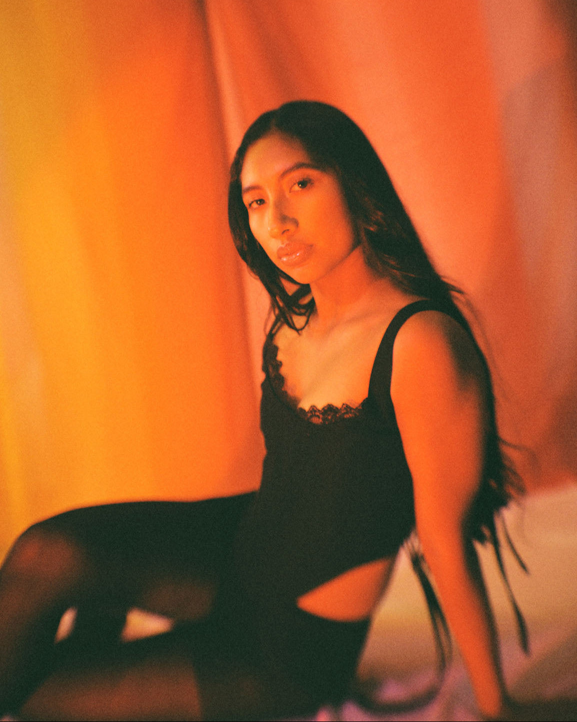 Side view of black corset top with lace trim and ribbon ties, handcrafted in cotton by Mariana by Alba