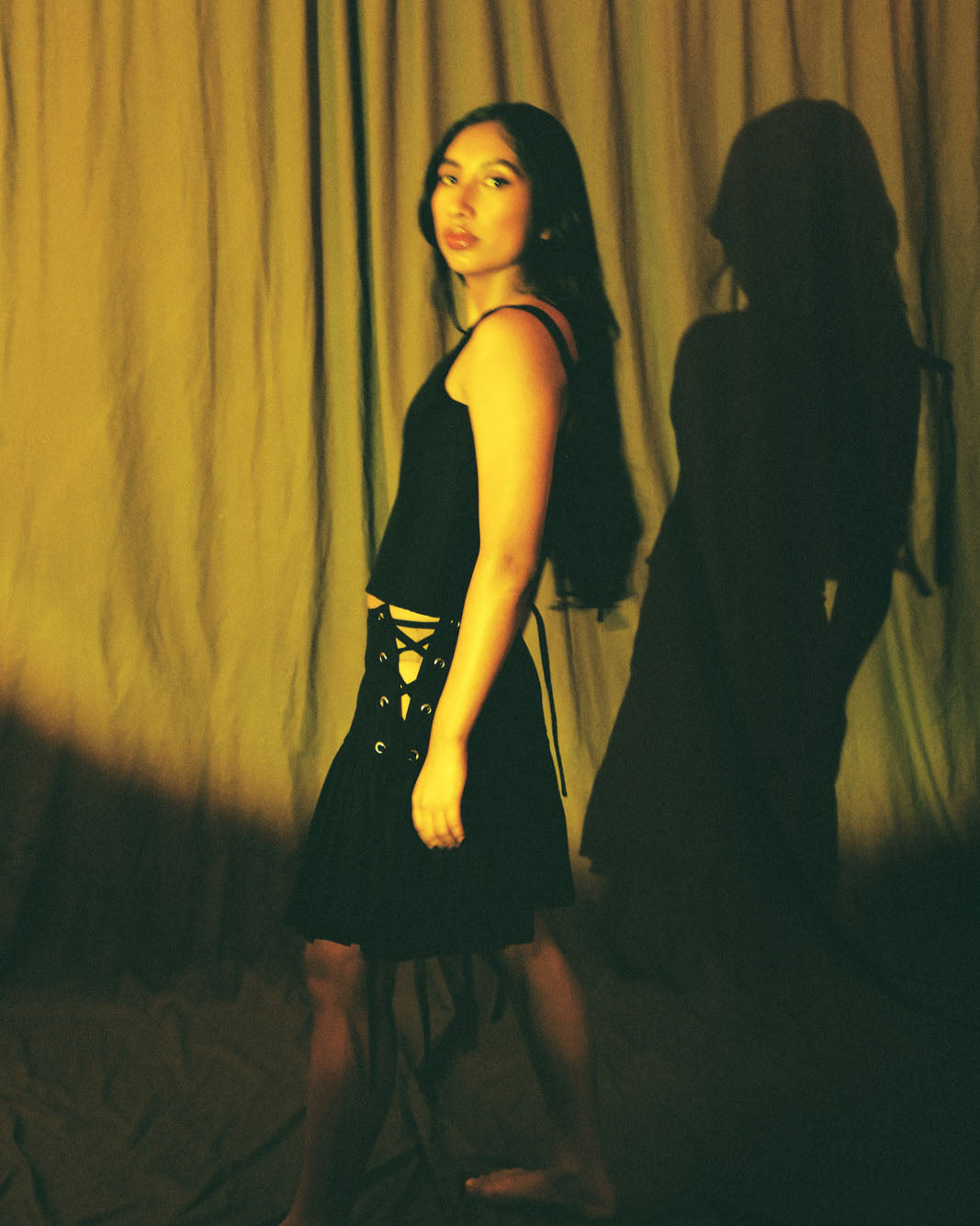 Black pleated corset skirt with adjustable lace-up sides by Mariana by Alba.
