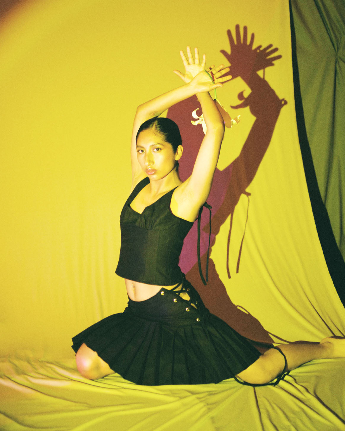 model dancing with black cotton corset top with scoop neckline and adjustable ribbon ties by Mariana by Alba.