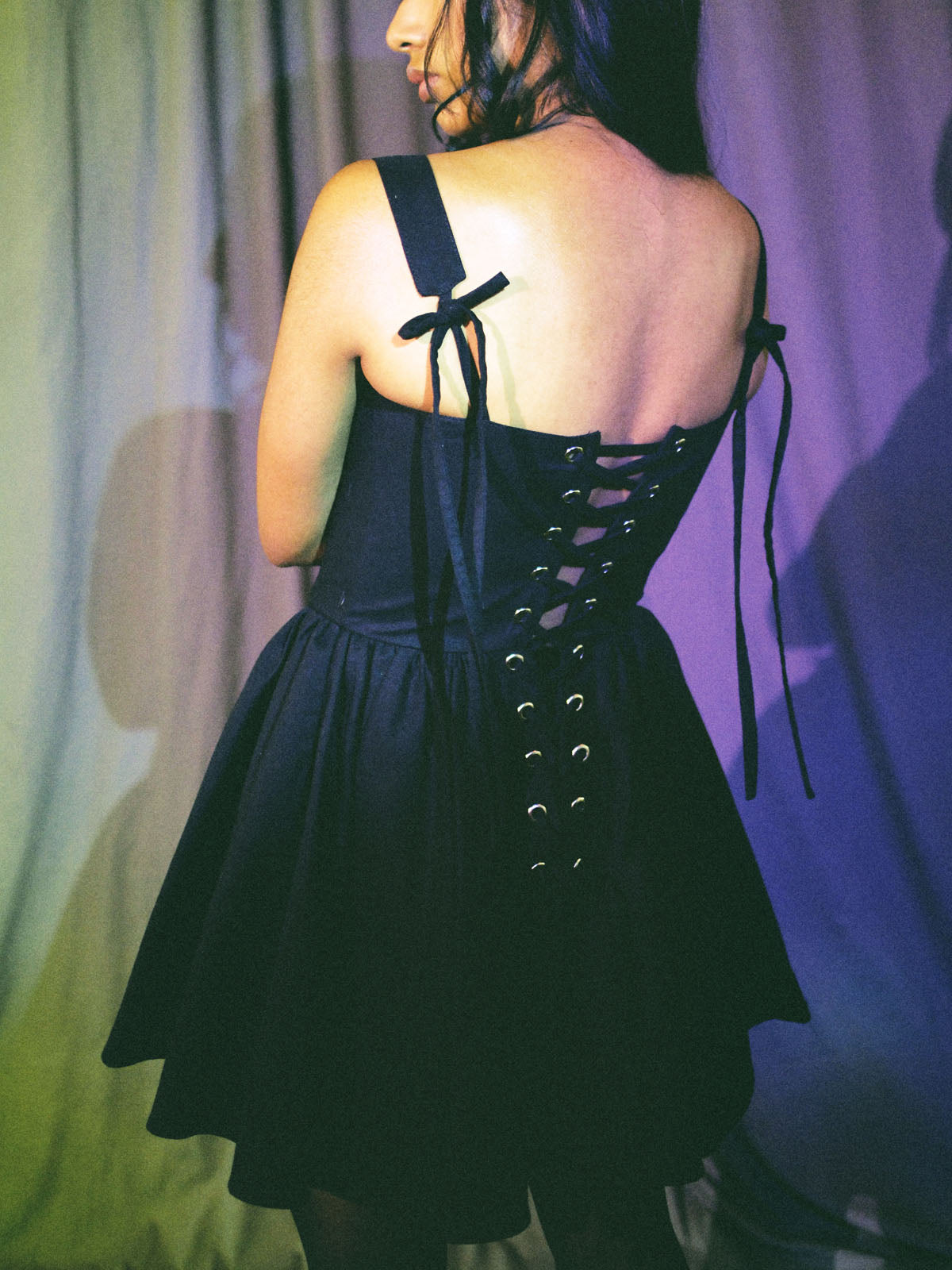 back view of black cotton corset dress with gathered skirt and ribbon lace-up details by Mariana by Alba