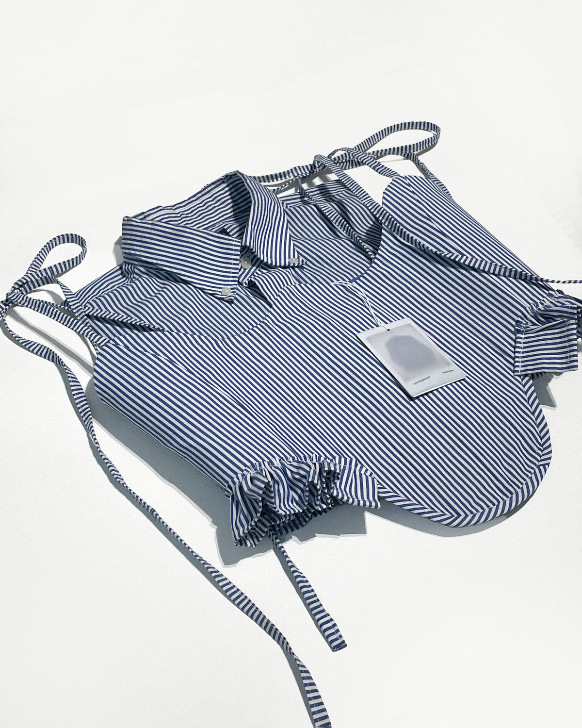 Blue and white striped apron with a matching shirt on a light gray background